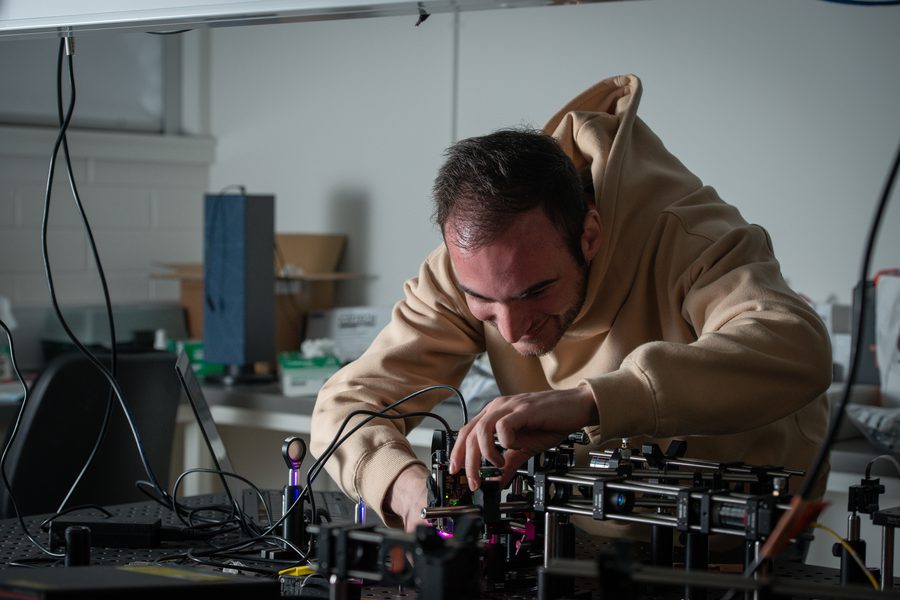 Dr Sulejman working at an optical bench, photographed for a Faculty of Science campaign