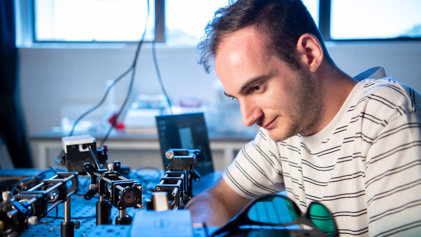Dr Sulejman aligning components on an optical bench in the laboratory