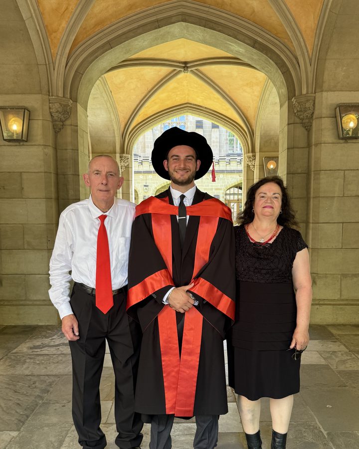 Dr Sulejman in doctoral academic dress with his parents in the University of Melbourne cloisters