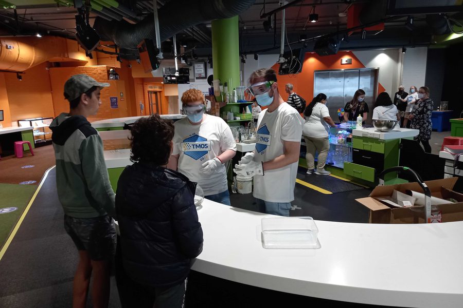 Dr Sulejman running a hands-on science demonstration at Questacon in a TMOS shirt
